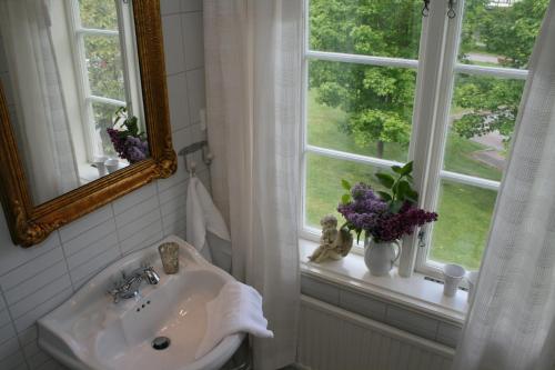 a bathroom with a sink and a window with flowers at Huskvarna Hotell & Vandrarhem in Huskvarna
