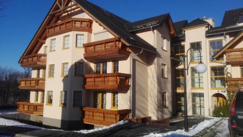 a building with wooden balconies on the side of it at Apartament Luna in Karpacz