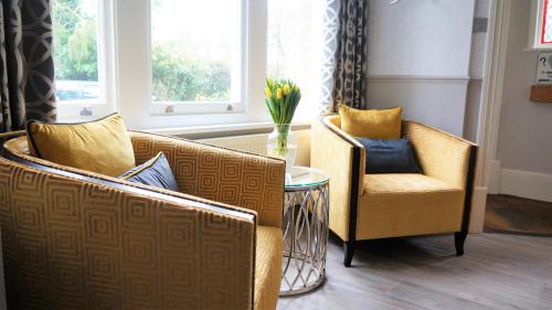 a living room filled with furniture next to a window at The Lawn Guest House Gatwick in Horley