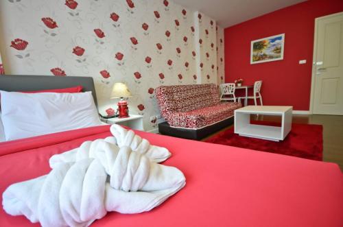 a red bedroom with a bed with a white blanket at Baan Imm Aim Condo Hua Hin in Hua Hin