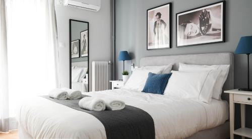 - une chambre avec un lit blanc et des serviettes dans l'établissement Modern Downtown Flat near the Acropolis by UPSTREET, à Athènes