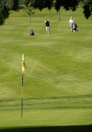 two people playing golf on a golf course at Resort Malevil in Jablonné v Podještědí