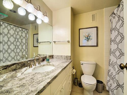 a bathroom with a sink and a toilet and a mirror at Regatta Beach Club C1009 2373 in Clearwater Beach