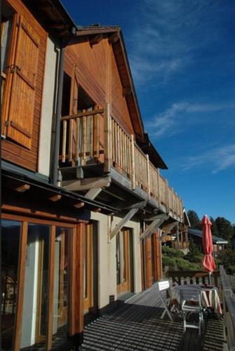 a wooden building with a balcony and a patio at Chalet l'Angélique in Bolquere Pyrenees 2000