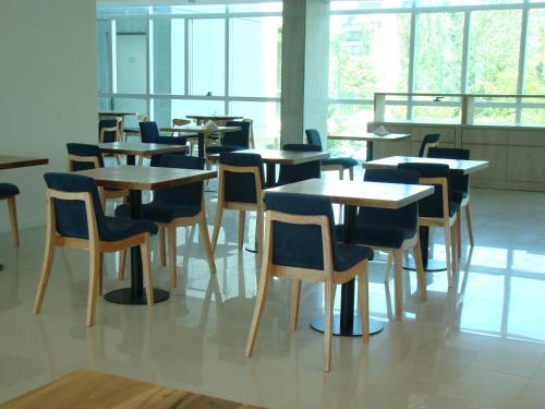 a group of tables and chairs in a room with windows at Dazzler by Wyndham Rosario in Rosario