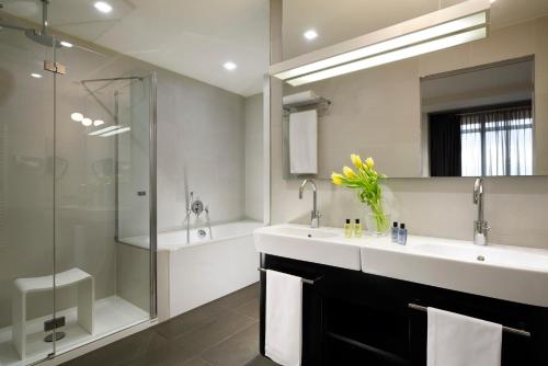 a bathroom with a large sink and a shower at UNAHOTELS San Vitale Bologna in Bologna