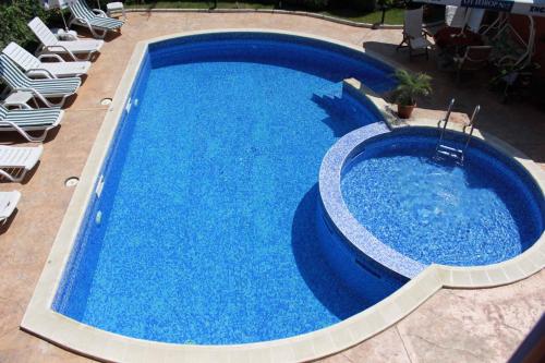 a large blue swimming pool with chairs around it at Green Hisar Hotel Family in Hisarya