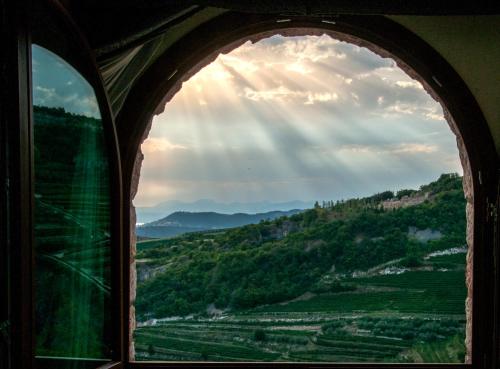 an arched window with a view of a valley at Villa San Giorgio in SantʼAmbrogio di Valpolicella