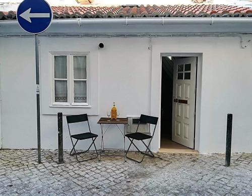 a table and two chairs in front of a white house at Casinhas da Ajuda nº 27 in Lisbon