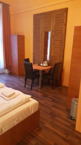 a room with a table and chairs and a table and a room with two beds at Pension Madara in Vienna