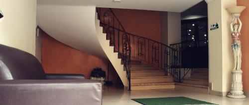 a living room with a staircase with a couch and a stair case at Hotel Santa Isabel 2 in Ipiales