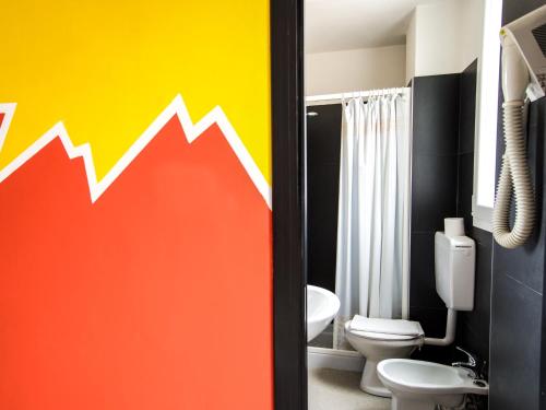 baño con una flecha colorida pintada en la pared en Hotel Elba, en Rímini
