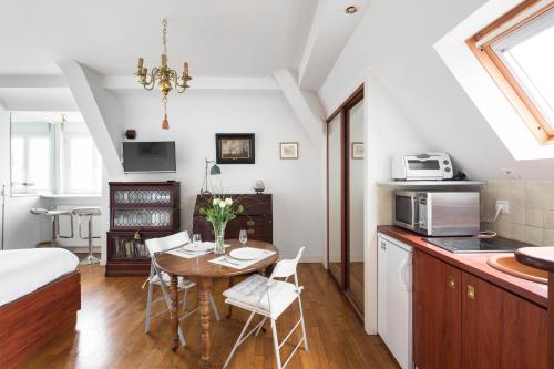 a kitchen and dining room with a table and a bed at Le Chateaubriand by Cocoonr in Saint Malo