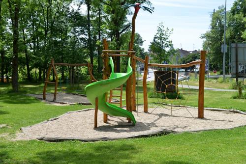 a playground with a green slide in a park at Penzion a Restaurace Pintovka in Tábor