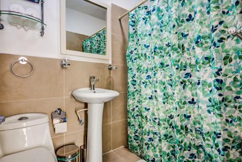 a bathroom with a sink and a shower curtain at Nomad Deluxe in Playa del Carmen
