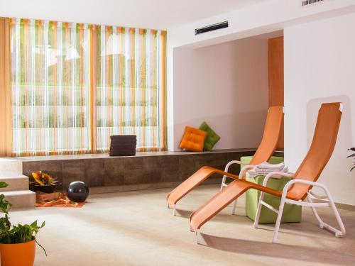a living room with two chairs and a couch at Hotel juenmi in Sillian
