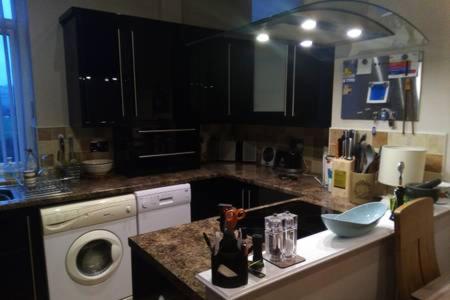 a kitchen with a counter with a washing machine at Bonny Colne On The Hill in Colne