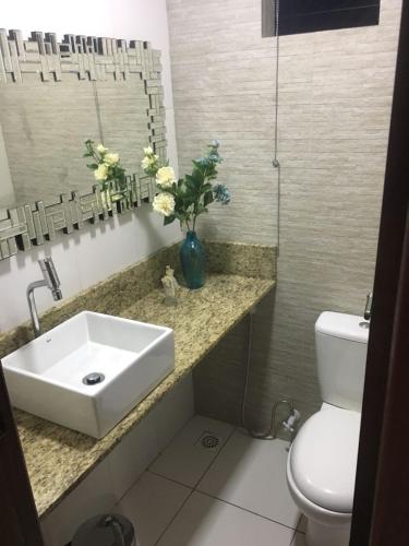a bathroom with a sink and a vase of flowers at Novo Hotel in Boa Vista