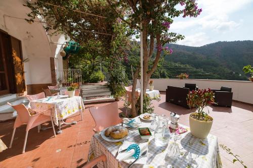 een patio met tafels en stoelen en uitzicht bij B&B Bouganville in Tramonti