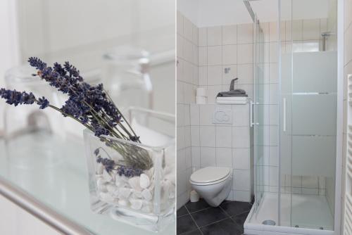 a bathroom with a toilet and a vase of flowers at Das Eberhart in Köflach