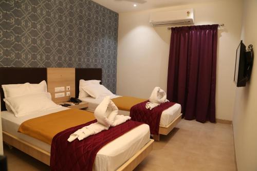 - 2 lits dans une chambre d'hôtel avec des serviettes dans l'établissement The Palm Residency- Ariyanoor, à Salem