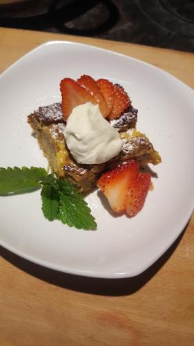 a plate of food with strawberries and whipped cream at El Rincon Eco Hotel in Los Ángeles