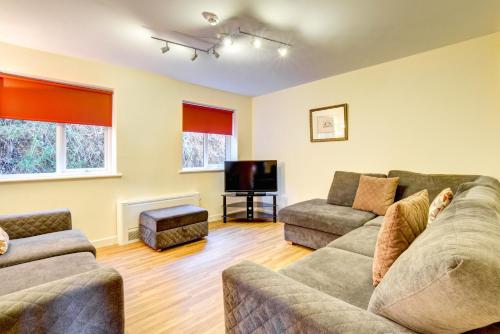 
a living room filled with furniture and a tv at Ysgubor y Coed in Pentyrch
