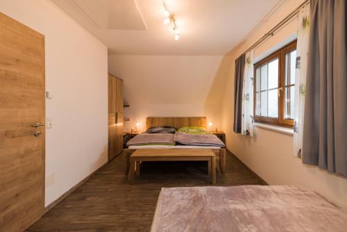 伊布斯河畔格施特靈的住宿－Biobauernhof Obereck，一间设有两张床和一张桌子的房间