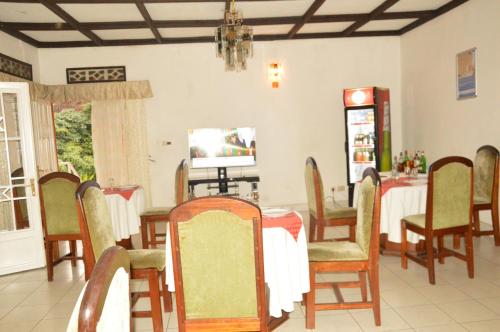 una sala da pranzo con tavolo e sedie di Ubumwe Hotel a Gisenyi