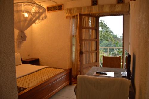 a bedroom with a bed and a window with a balcony at Ubumwe Hotel in Gisenyi
