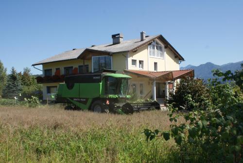 a green truck parked in front of a house at Biohof Naturzeit Faaker See in Drobollach am Faakersee
