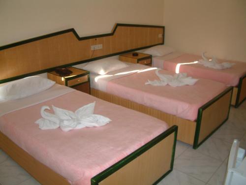 a room with three beds with white flowers on them at Diana Hotel Hurghada in Hurghada