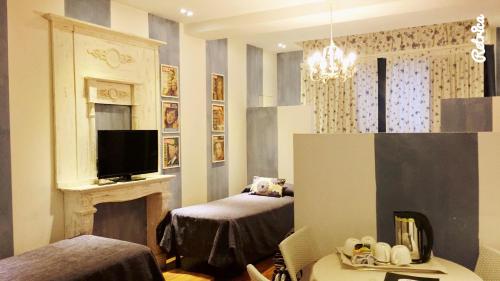a room with two beds and a fireplace and a television at Hotel Il Guercino in Bologna