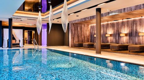 a swimming pool in a hotel room with chairs at Mountain Spa Residences in Sankt Anton am Arlberg
