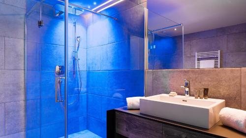 a bathroom with a sink and a shower at Mountain Spa Residences in Sankt Anton am Arlberg