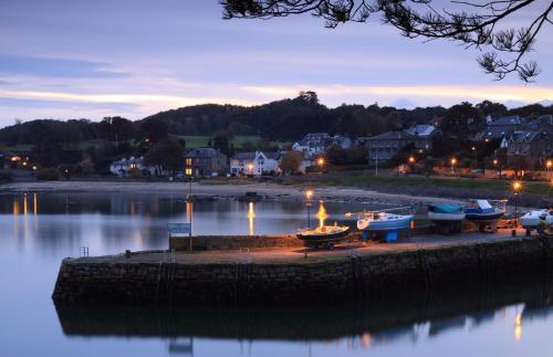 a group of boats on the shore of a body of water at Aberdour Hotel, Stables Rooms & Beer Garden in Aberdour