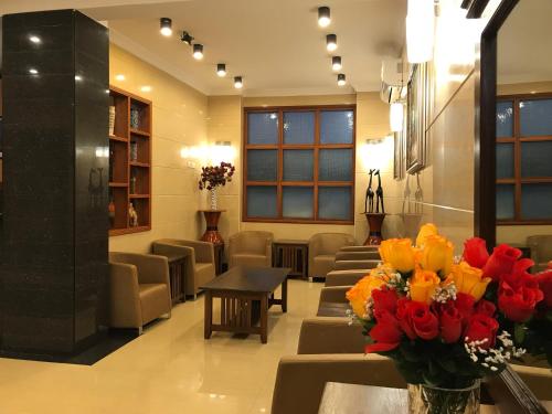a waiting room with chairs and a table with flowers at Chelsea Hotel in Dar es Salaam