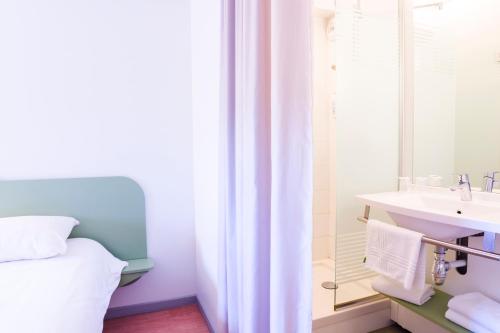a bathroom with a bed and a sink at Ibis Budget Valence Sud in Valence