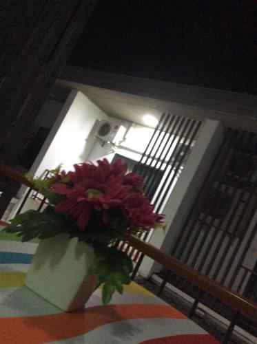 a vase of flowers sitting on a table at Amaretto Hostel in Surat Thani