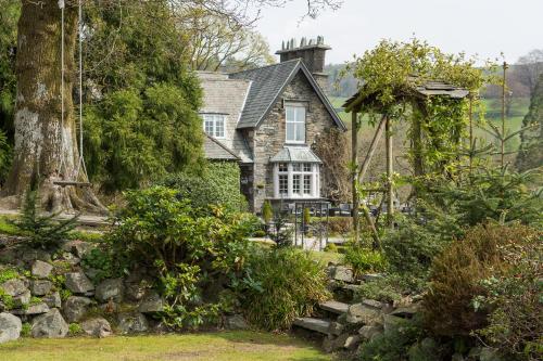 an old house with a stone wall in front of it at Broadoaks Boutique Country House in Windermere