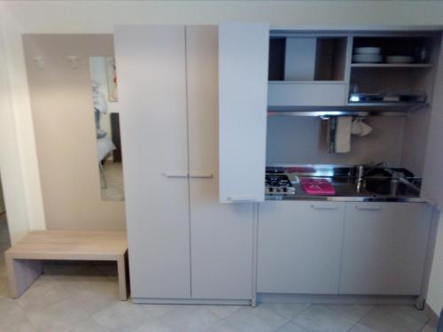 a small kitchen with white cabinets and a table at Salvia e Timo Rooms in Borso del Grappa