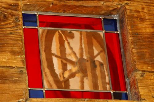 a stained glass window in a wooden wall at Troadkasten - Ferienhaus am BIO-Bergbauernhof in Aflenz Kurort