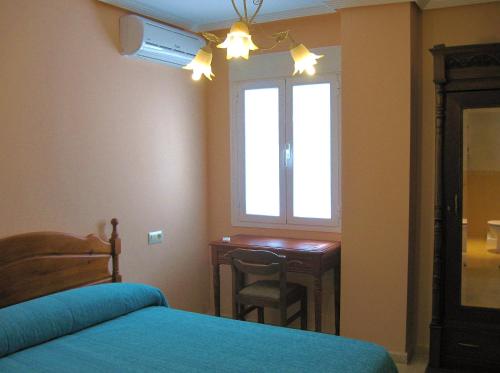 プラセンシアにあるValle del Jerteのベッドルーム(デスク、ベッド、窓付)