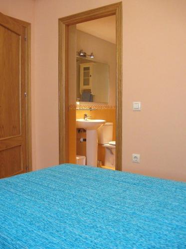 a bedroom with a blue bed and a mirror at Valle del Jerte in Plasencia