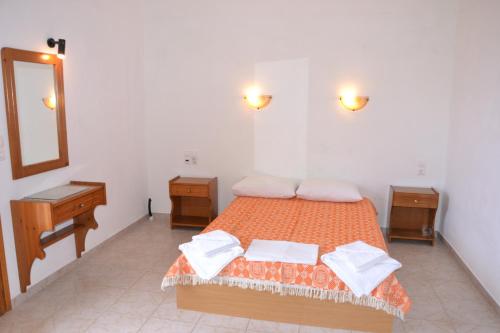 a bedroom with a bed and a mirror and a sink at Hellen Studios in Megali Ammos