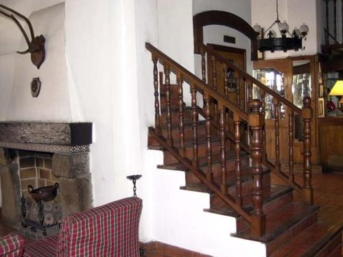 a wooden staircase in a living room with a fireplace at Hotel Regidor in Salta