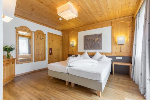 - une chambre avec un lit et un plafond en bois dans l'établissement Hotel Burgstall, à Neustift im Stubaital