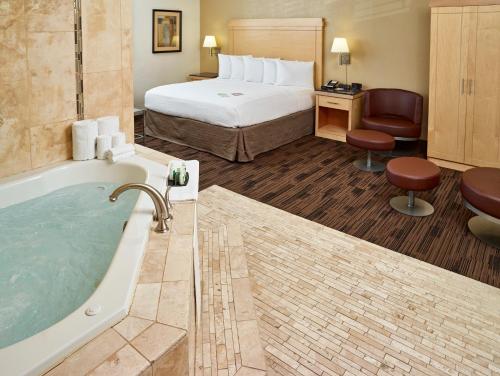 a hotel room with a tub and a bed at LivINN Hotel St Paul East / Maplewood in Maplewood