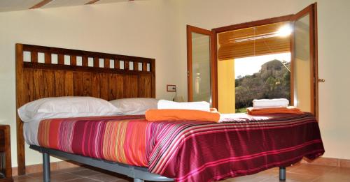 a bedroom with a large bed with a window at Cal Tresonito in Coll de Nargó