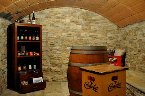 a wine cellar with a barrel and a shelf of wine bottles at Cal Tresonito in Coll de Nargó